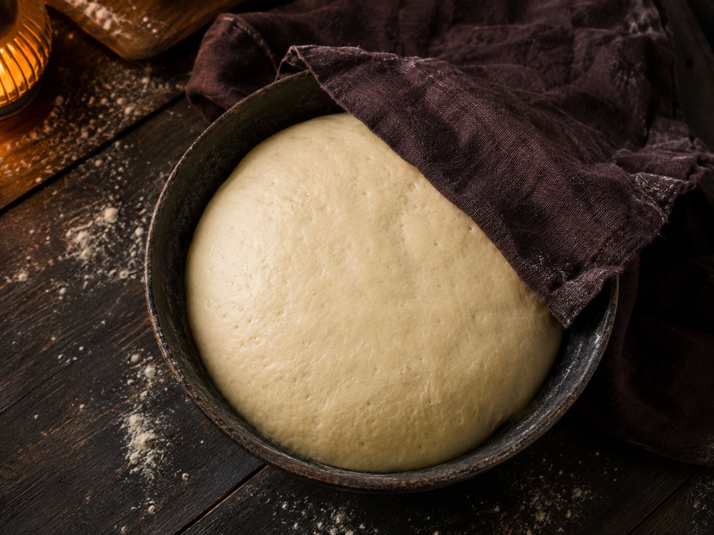 Pretzel bites dough proofed and doubled in size in a bowl under a cloth