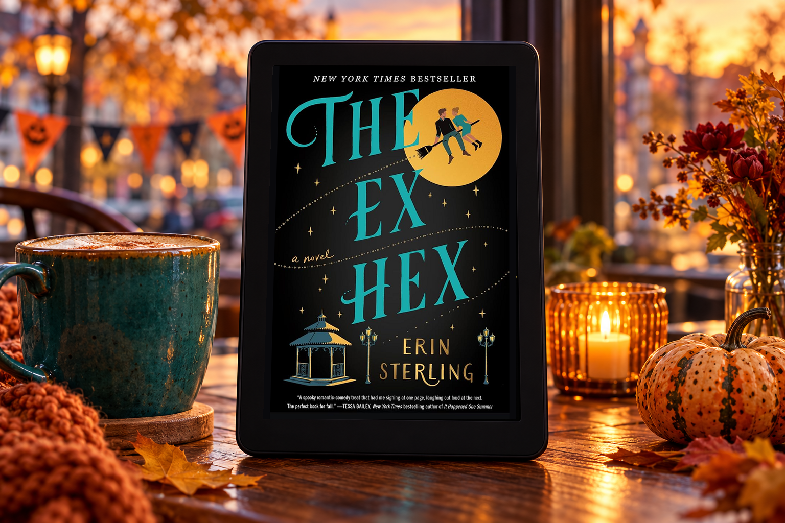 The Ex Hex on a Kindle beside a teal mug overlooking an autumn cafe street.