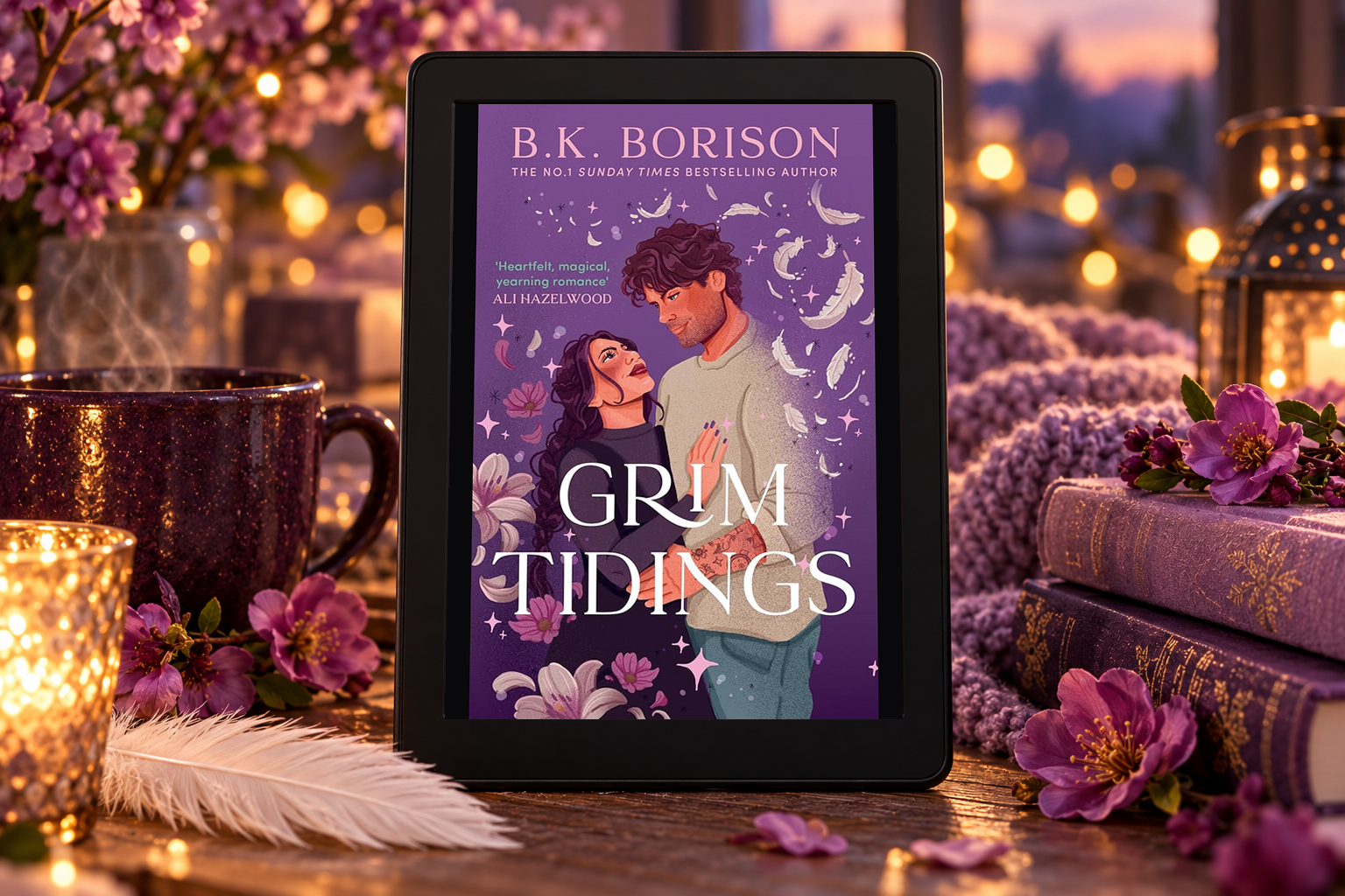 Grim Tidings on a Kindle beside a white feather, purple flowers and a warm drink.