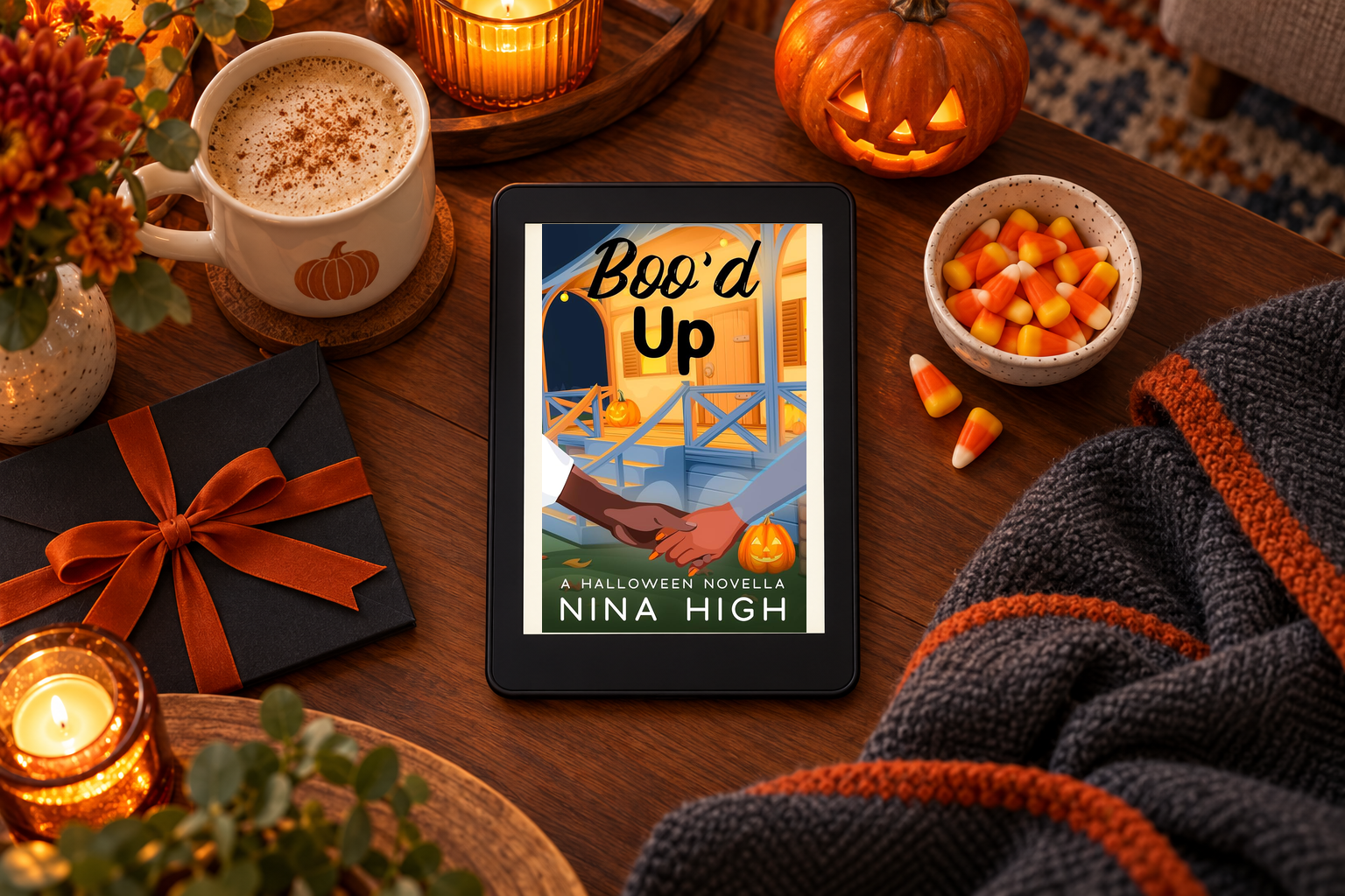 The original Boo'd Up cover appears on a black Kindle beside candy corn, a pumpkin mug and a charcoal blanket.